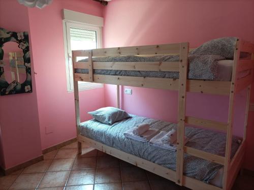 1 dormitorio con 2 literas en una habitación con paredes rosas en La Cariñosa en Naveces