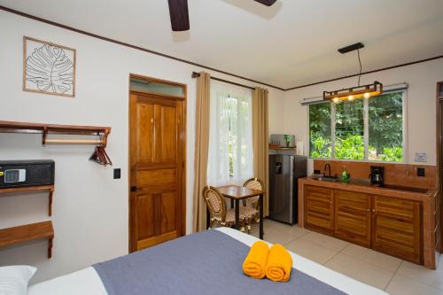 a bedroom with a bed and a kitchen with a sink at Manzanillo Caribbean Resort in Puerto Viejo