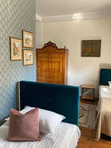 sypialnia z niebieskim zagłówkiem i dwoma łóżkami w obiekcie Villa Italiana pokoje z prywatnymi łazienkami & Odnowa Biologiczna w mieście Gdynia