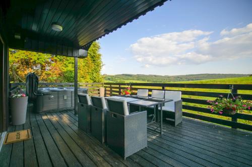 a patio with a table and chairs on a deck at Glenview Chalet Park in Inverness