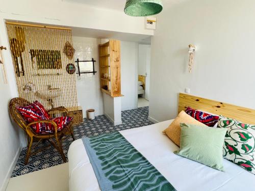 sypialnia z łóżkiem i krzesłem w pokoju w obiekcie Coco bay 2 w mieście Saint-Benoît-des-Ondes