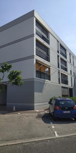 une voiture garée sur un parking devant un immeuble dans l'établissement Appartement 30m2 classé 2 étoiles Atout France 200m port plages commerces, à Saint-Cyprien