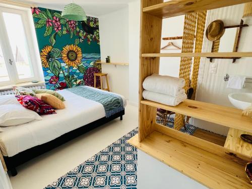 a bedroom with a bed and a bathroom with a sink at Coco bay 2 in Saint-Benoît-des-Ondes
