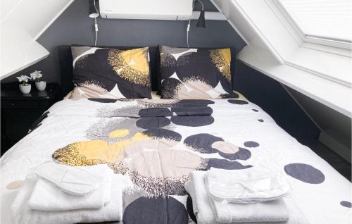 een bed met een dekbed en kussens erop bij Beautiful Home In Bunschoten-spakenb, With 1 Bedrooms And Wifi in Bunschoten