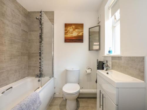 a bathroom with a toilet and a sink and a tub at Hadleigh Farm Cottage in King's Lynn