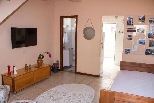 ein Schlafzimmer mit einem Bett, einer Kommode und einem TV in der Unterkunft Casa de 2 Suítes com Internet Rápida e Comodidades in Belo Horizonte