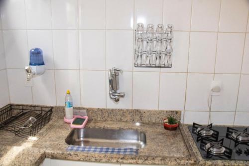 um balcão de cozinha com um lavatório e um fogão em Casa de 2 Suítes com Internet Rápida e Comodidades em Belo Horizonte