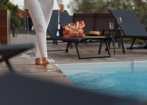 een vrouw staat naast een zwembad bij Aria di Mare Apartments in Tivat