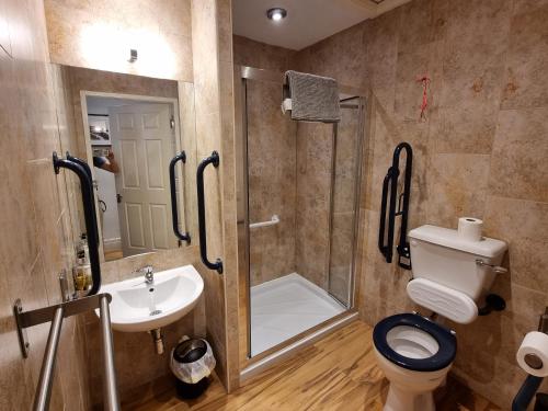 a bathroom with a shower and a toilet and a sink at Granada Apartments Berkeley in Blackpool