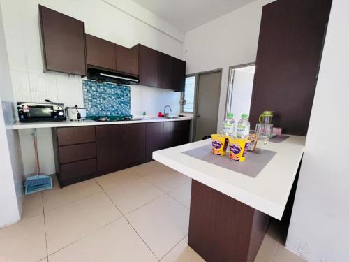 a kitchen with brown cabinets and a white counter top at Daddy Homes Golden Hills pasar malam cameron 3bedroom in Brinchang