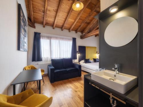 a bathroom with a sink and a living room with a couch at Don Pablo Playa de Somo in Somo