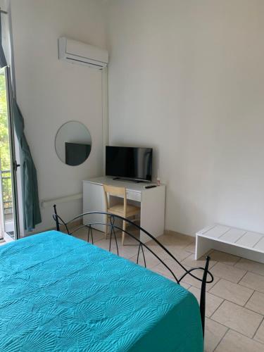 a bedroom with a bed and a tv and a table at GARIBALDI ROOMS in Reggio Calabria