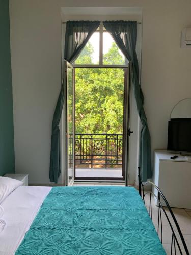 ein Schlafzimmer mit einem Bett und einem großen Fenster in der Unterkunft GARIBALDI ROOMS in Reggio di Calabria