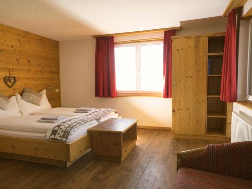 a bedroom with a large bed and a window at Hotel Aletschhorn in Belalp