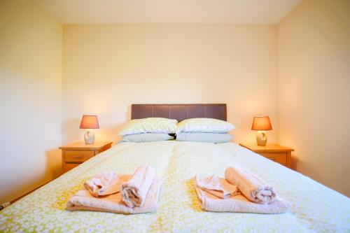 a bedroom with a bed with towels on it at Glenview Chalet Park in Inverness