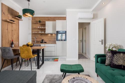 eine Küche und ein Wohnzimmer mit einem grünen Sofa in der Unterkunft Deluxe Kvarner 2 in Lovran