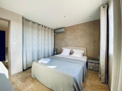 une chambre avec un grand lit avec des draps blancs dans l'établissement Villa Arizona, à Fréjus