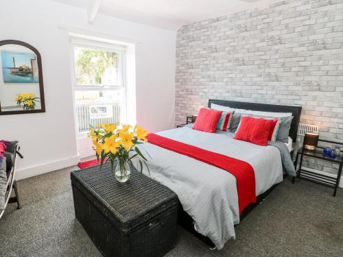 a bedroom with a large bed and a brick wall at Bridge Cottage in Haltwhistle