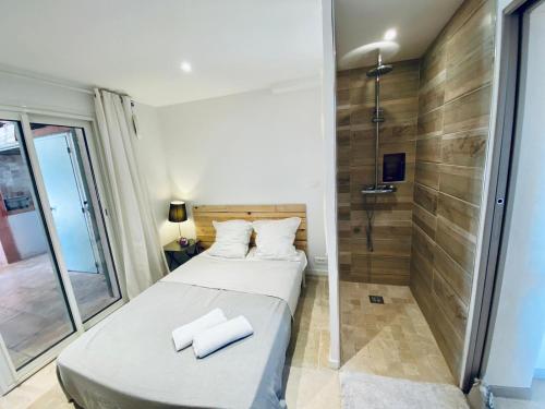 une petite chambre avec un lit et une douche dans l'établissement Villa Arizona, à Fréjus