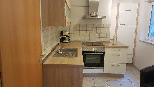 a small kitchen with a sink and a stove at Im Beilsteiner Mühlental in Beilstein