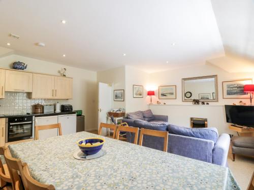 a kitchen and living room with a table and a couch at The Mews Flat in Dalswinton