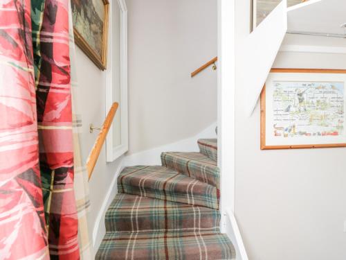 a stairway with a plaid stair runner at The Mews Flat in Dalswinton