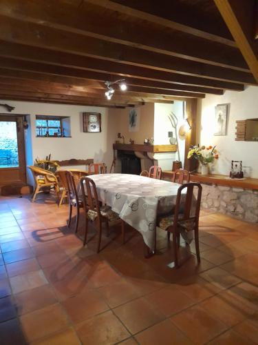 une salle à manger avec une table et des chaises blanches dans l'établissement Les Ronzières, à Les Salles