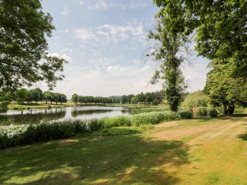 a view of a river with trees and a field at The Mews Flat in Dalswinton