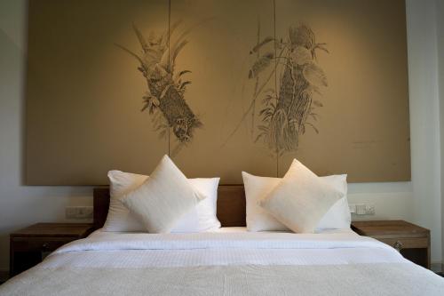 a bedroom with a bed with white pillows at Jetwing Blue in Negombo
