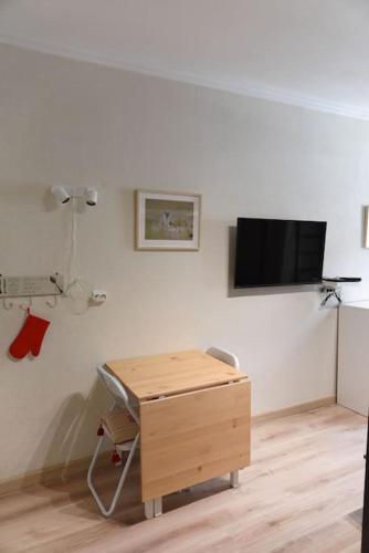 Una habitación con un escritorio y un televisor en la pared. en Nid Douillet classé 2 étoiles depuis janvier 2023, en Le Mont-Dore
