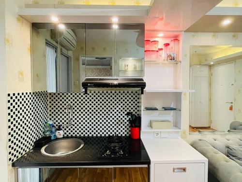 a bathroom with a sink and a kitchen with a couch at property 2A in Jakarta