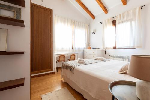 una camera con letto, tavolo e finestre di CASA TIERRA - Casas Los Elementos a Zahora
