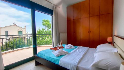 a bedroom with a bed and a large window at Alex House Garden in Iraklitsa