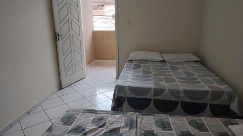 um quarto com uma cama e uma porta para um quarto em 101 Apartamento em Aracruz ES em Aracruz
