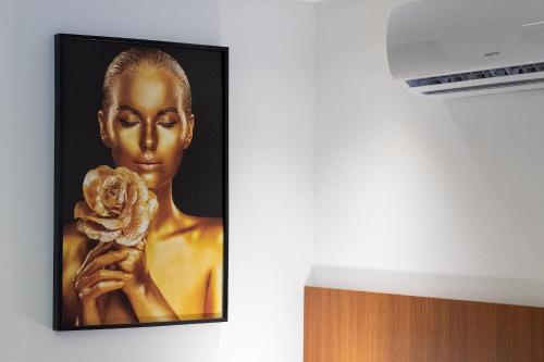 a picture of a woman holding a flower on a wall at Unity #110 - Apartamento ao mar por Carpediem in Penha