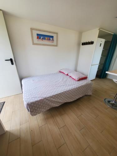 a bedroom with a bed and a wooden floor at Bongraine Océan in La Rochelle