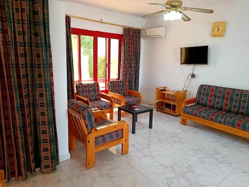 a living room with two chairs and a couch at فيلا رائعة في منتجع سانتا مونيكا مرسي مطروح عائلات فقط in Marsa Matruh