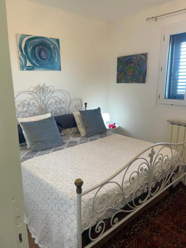 uma cama num quarto com duas pinturas na parede em Villa Bella em Augusta
