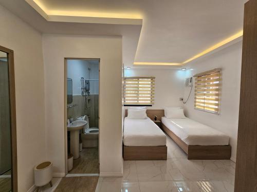 2 camas en una habitación con baño en MGS Property en General Santos