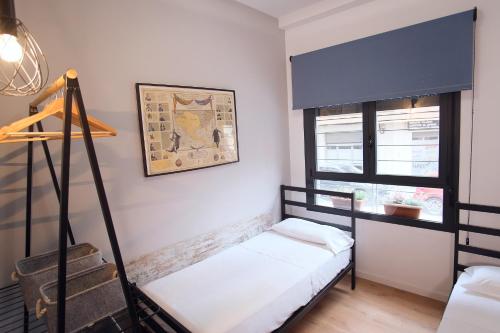 Zimmer mit 2 Etagenbetten und einem Fenster in der Unterkunft Ibanova Homes Casco Antiguo 2 in Valencia