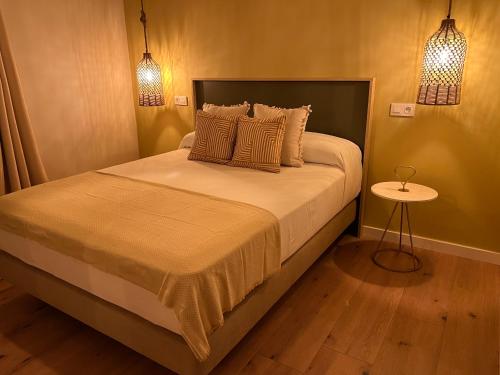 a bedroom with a bed with two lamps and a table at Casal de pelaio in Barreiros