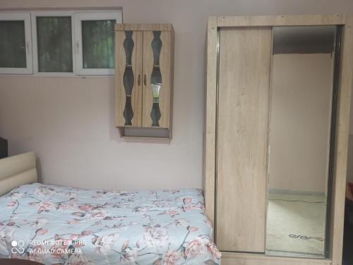 een slaapkamer met een bed en een houten kast bij Самгори in Tbilisi City