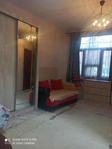 een woonkamer met een bank en een spiegel bij Самгори in Tbilisi City