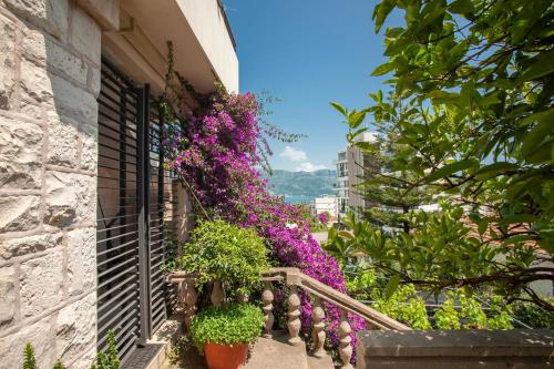 un balcón con flores en el lateral de un edificio en Apartments and Rooms Teona, en Budva