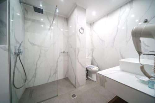 a white bathroom with a shower and a toilet at Amalia Apartments in Balíon