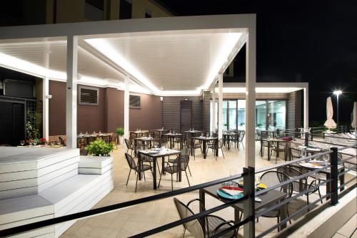 a restaurant with tables and chairs on a balcony at night at Hotel Ristorante Dante in Torgiano