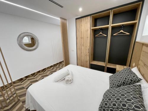 1 dormitorio con cama blanca y espejo en Loft Concejo Plaza Mayor, en Salamanca