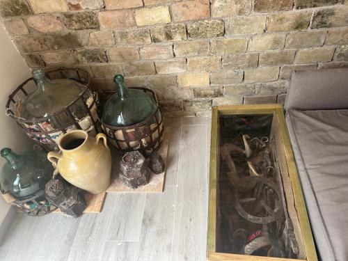 a group of vases and a mirror next to a brick wall at Stablus house in Alykes Potamou