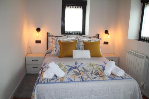 ein Schlafzimmer mit einem großen Bett mit gelben Kissen in der Unterkunft Casa vacacional Escuela la Llera in Colunga