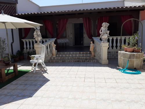 een patio met een witte stoel en een parasol bij villino scianuli in Torre Squillace